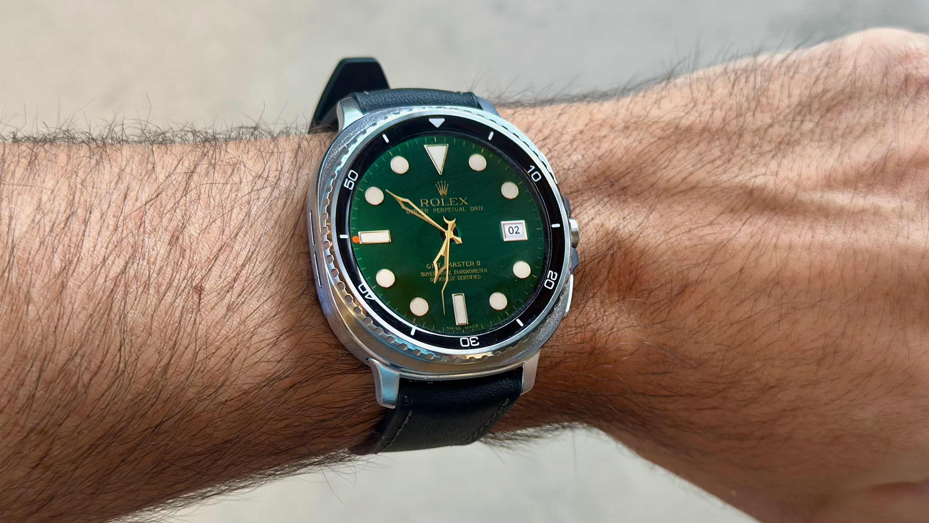 The Samsung Galaxy Watch 8 Classic on a person's wrist, showing a custom watch face from the TIMEFLIK app imitating a Rolex luxury watch face.