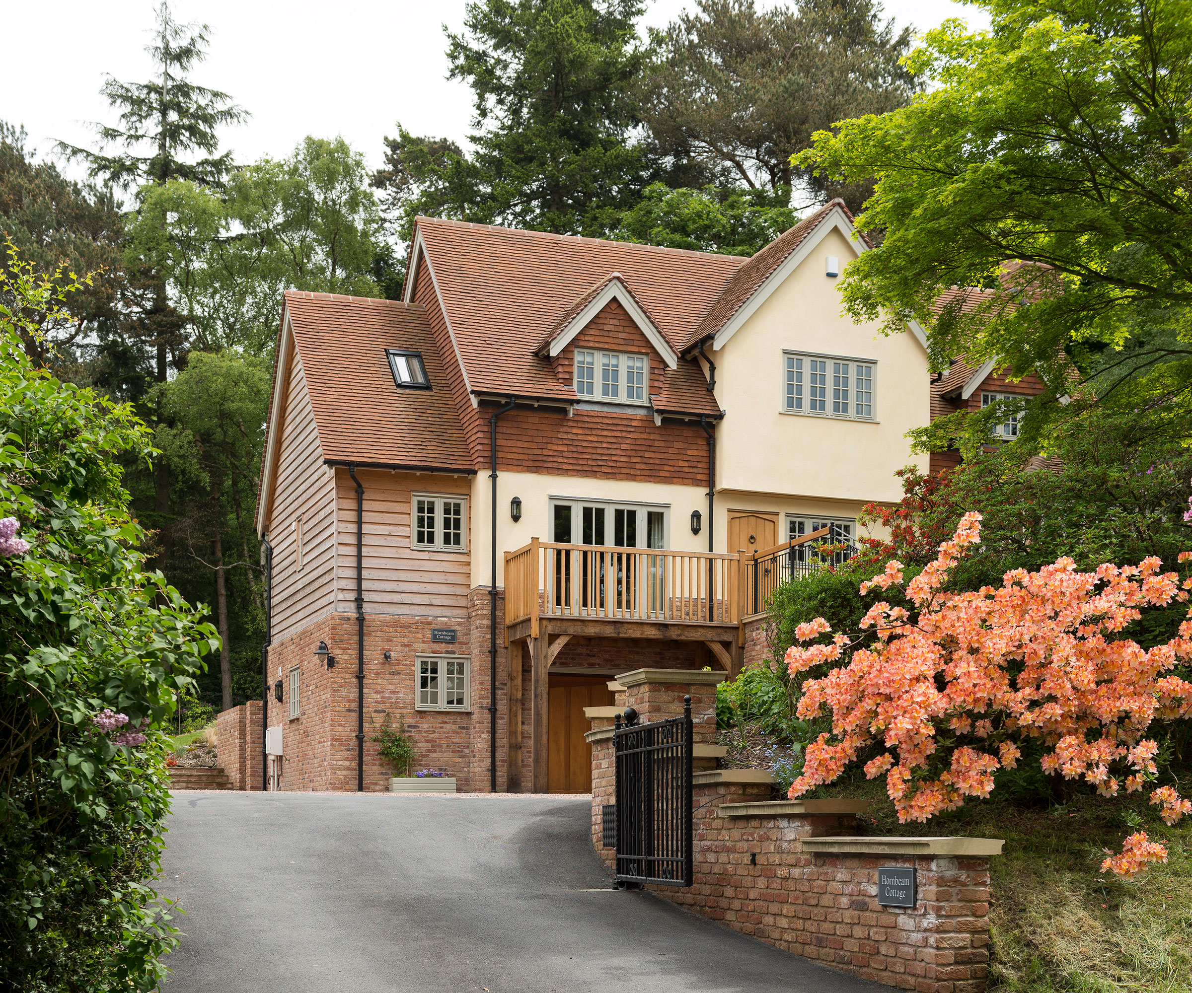 three storey timber frame self build by Border Oak with sloping tarmac driveway
