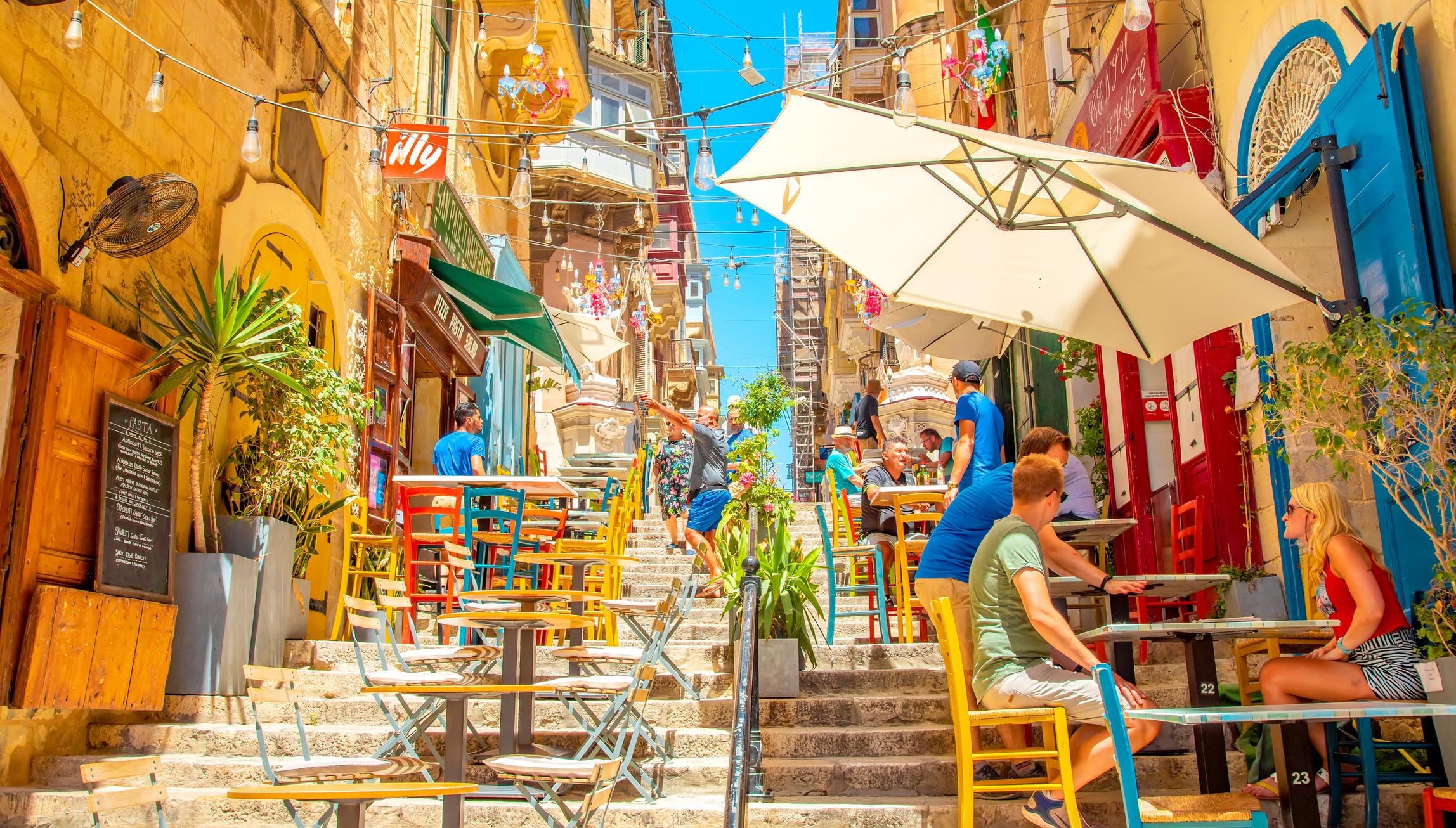 Street summer cafe in Valletta old town, Malta. People sitting in a cafe.