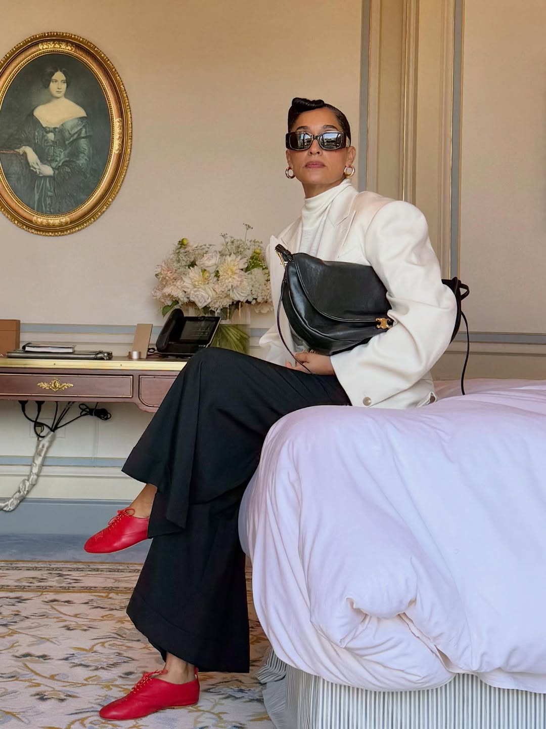 Tracee Ellis Ross in white blazer, black trousers and red trainers