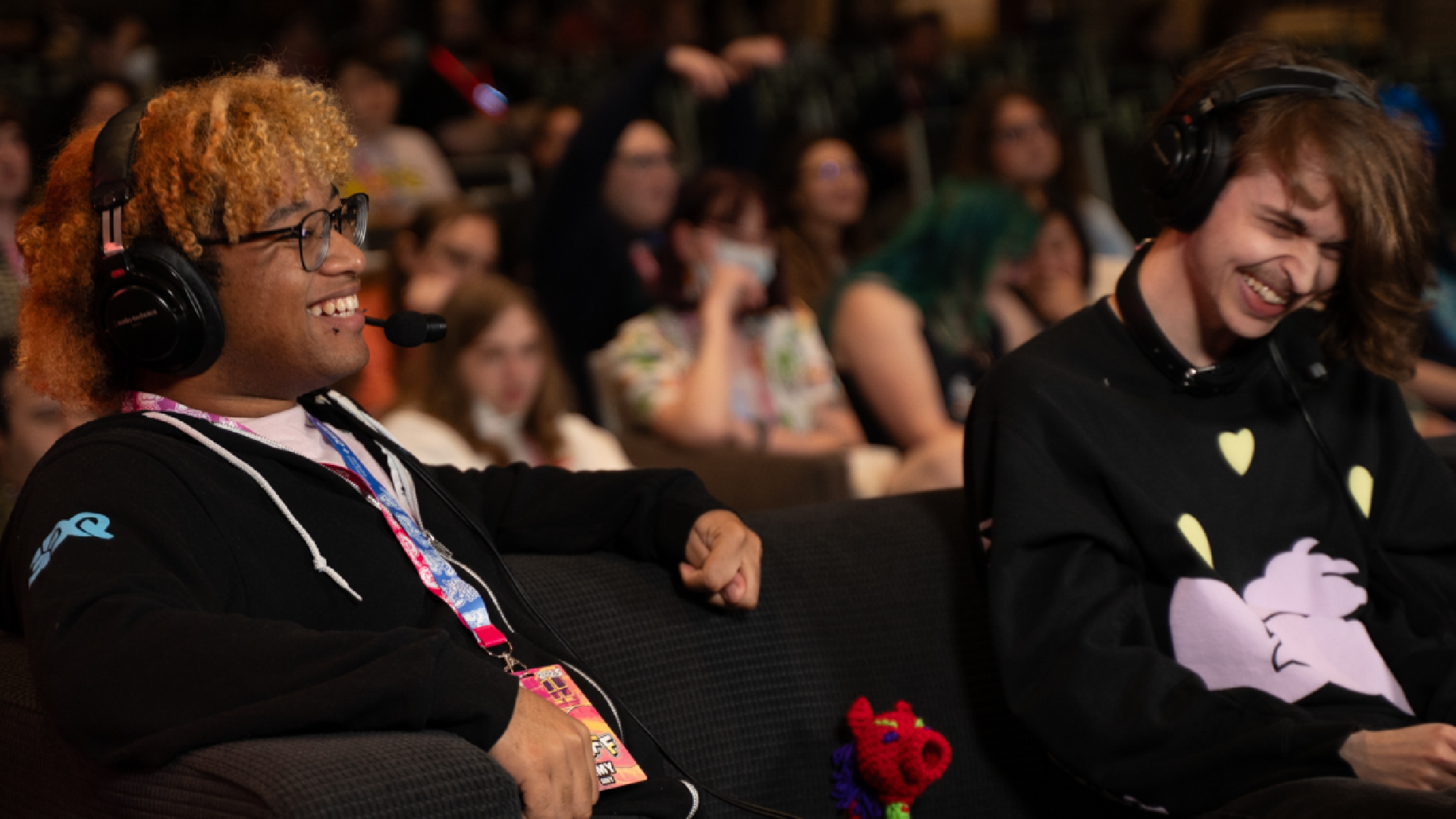 A crowd gathers at Games Done Quick, while two commentators laugh at the game they're broadcasting.