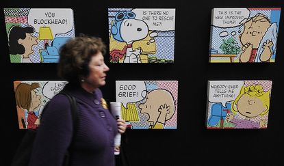 A woman walks by "Peanuts" cartoons.