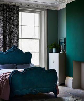 dark turquoise bedroom with and bed with large bedframe