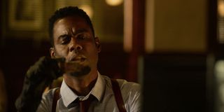 Chris Rock puzzles over a flash drive in his hands in Spiral: From the Book of Saw.
