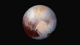 Pluto against the black background of space. The planet is a mix of colors from dark blood-red to white and a dusting of yellow at the top. In the lower right side of the image, the large white expanse of the Tombaugh Regio takes the shape of a heart. 