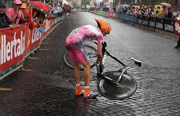 Denis Menchov prepares to remount his time trial bike after crashing on the slippery streets.