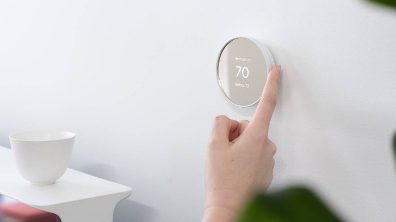 Someone adjusting a Google Nest thermosta