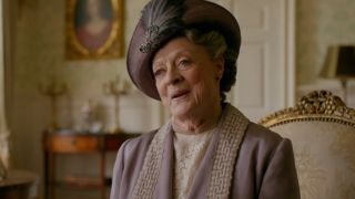 Dame Maggie Smith smiles as she sits in a brightly lit conversation in Downton Abbey.