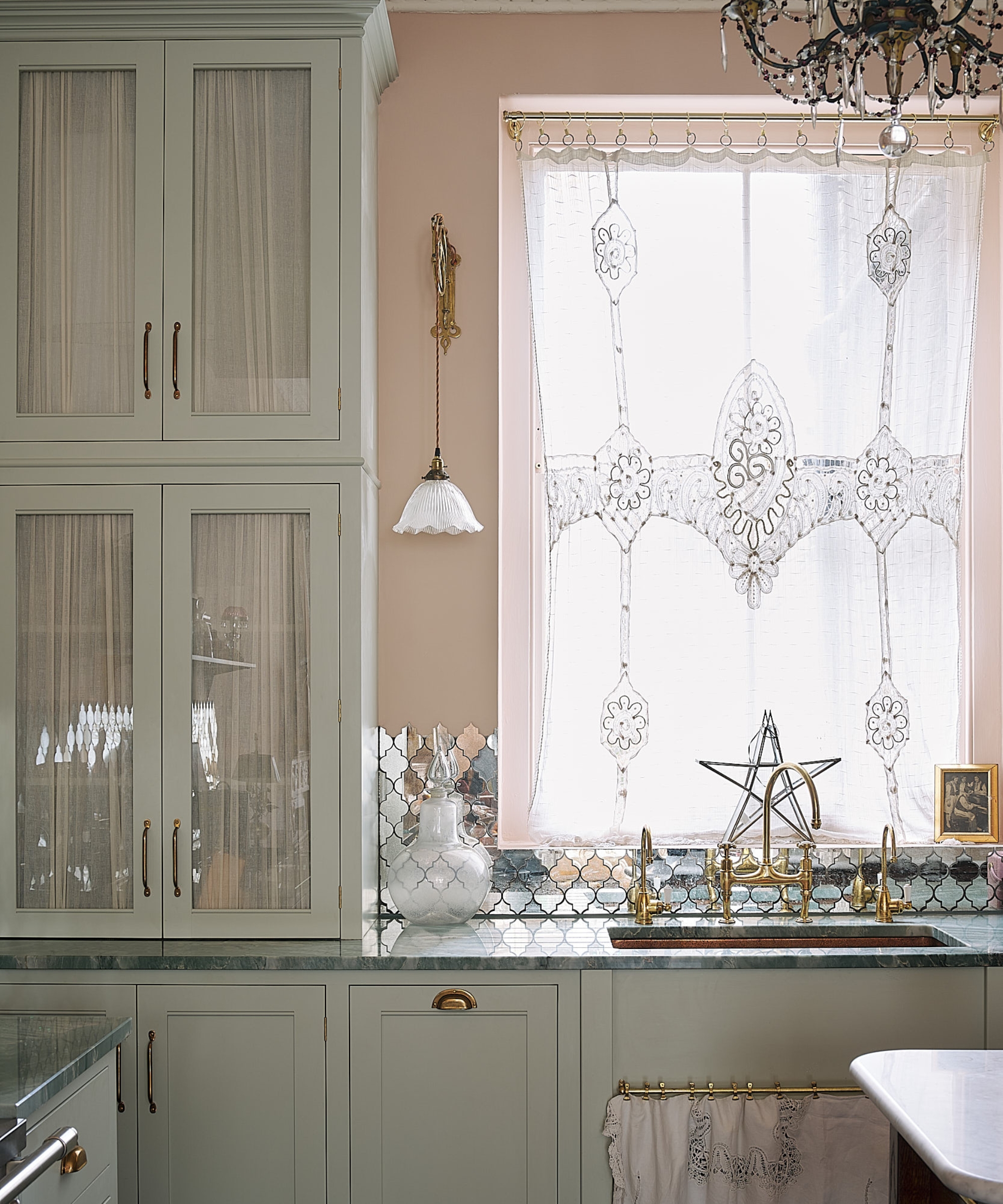 A mint green kitchen with a mirrored splashback