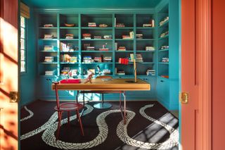 home office with blue bookshelves and snake rug on the floor