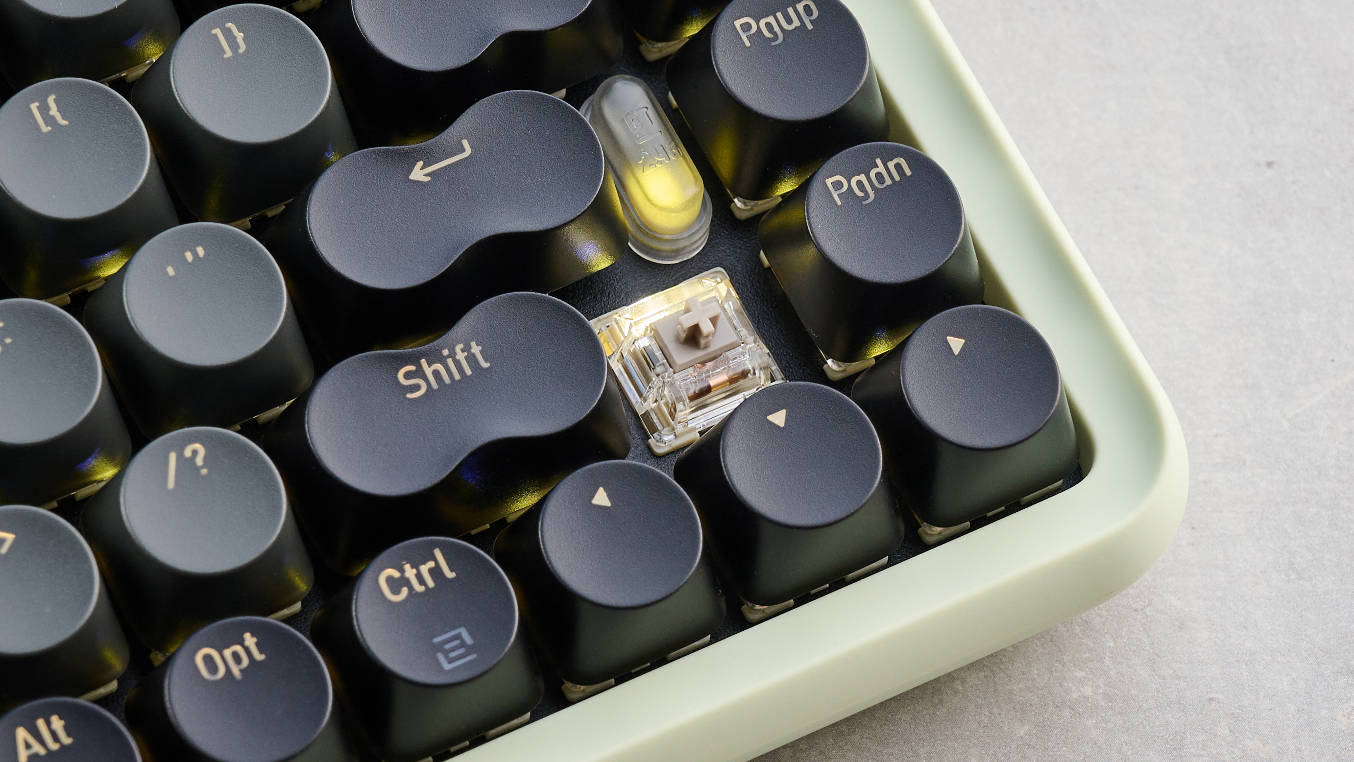 The Lofree DOT on a stone surface with a keycap removed showing the switch