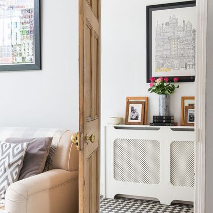 room with wooden door and photoframe on white wall