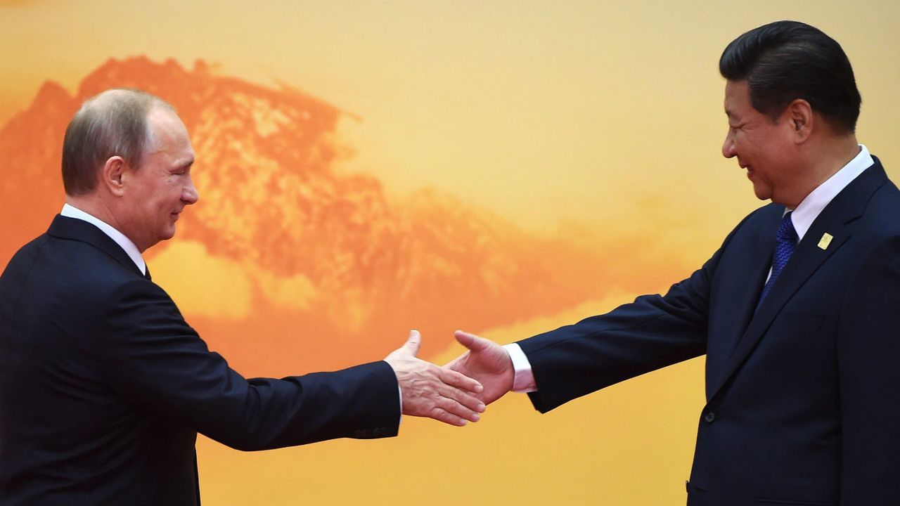 Vladimir Putin shakes hands with Xi Jinping at the Asia-Pacific Economic Cooperation summit