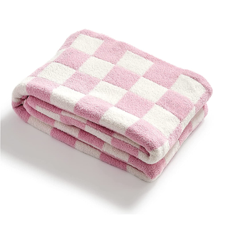 A white and pink checkered fluffy throw blanket