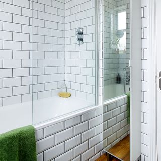 bathroom with bathtub and white tiles wall