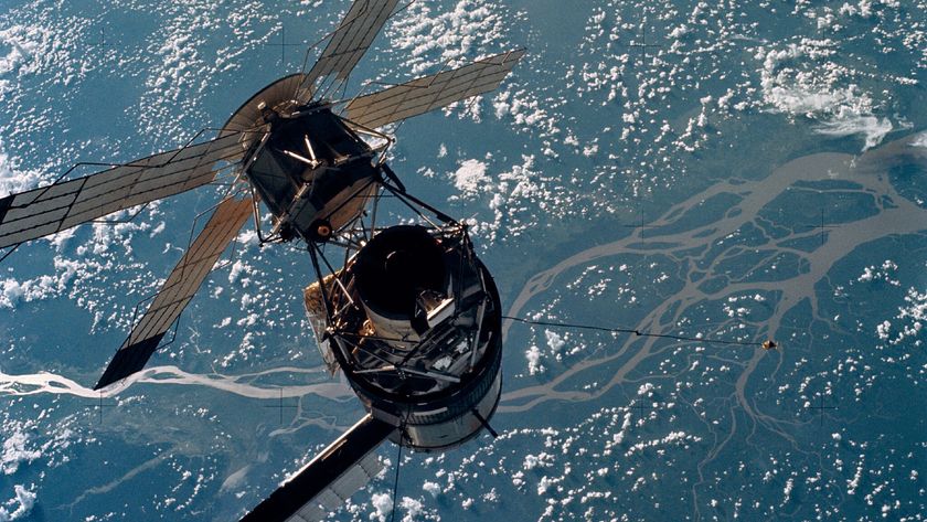 A large space station with solar panels floats above an ocean