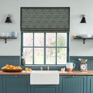 kitchen with blue cabinets and white washbasin and window blinds