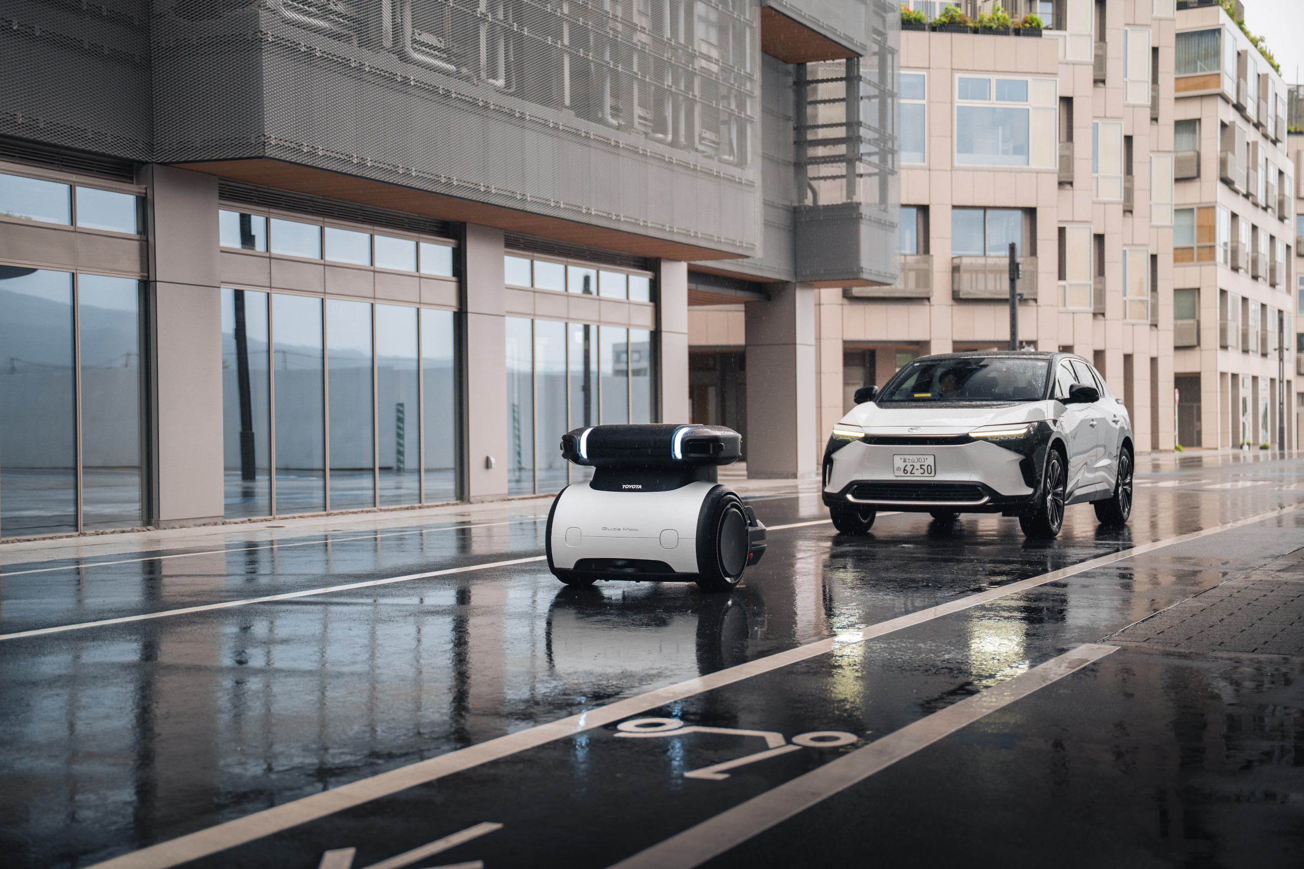 Toyota Guide Mobi ahead of a Toyota bz4x on the streets of Woven City