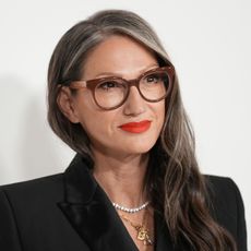 Jenna Lyons wears large eyeglasses and a black blazer