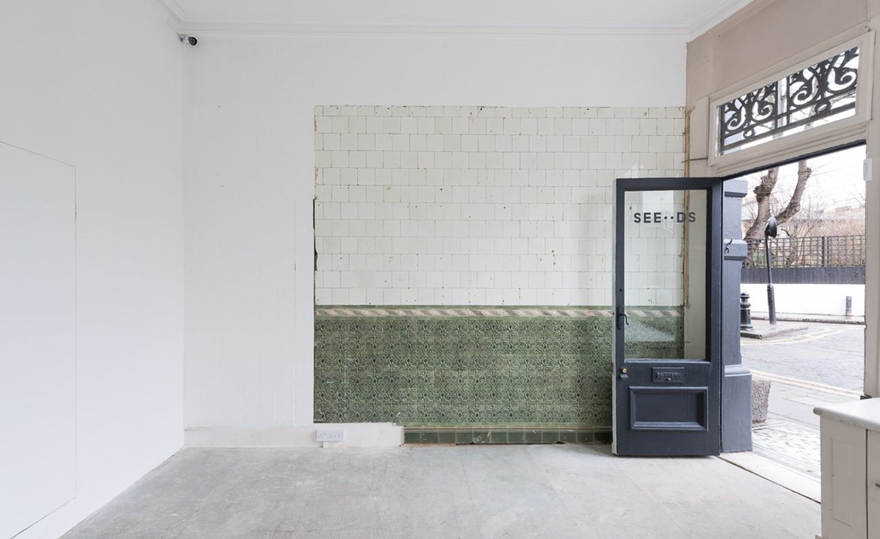 White room with large doors opening onto a street.