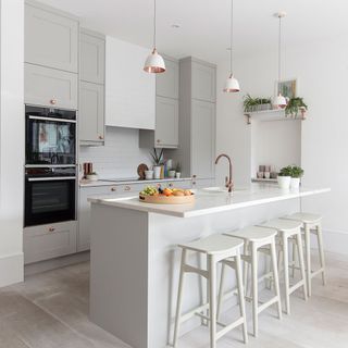 Bright and airy london kitchen with island, stools and pendant lights