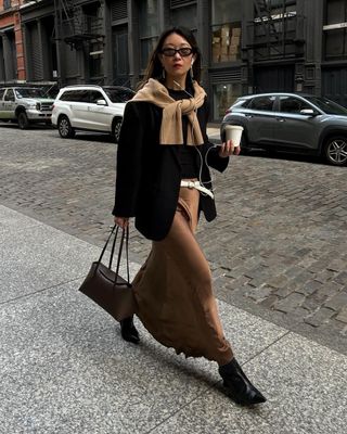 Brown satin skirt with black blazer and heeled boots