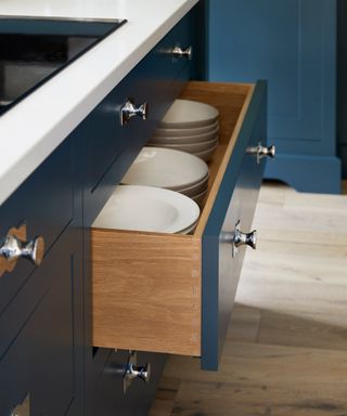 Deep kitchen drawers stacked with white crockery