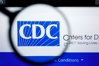 A magnifying glass over CDC&#039;s logo online.