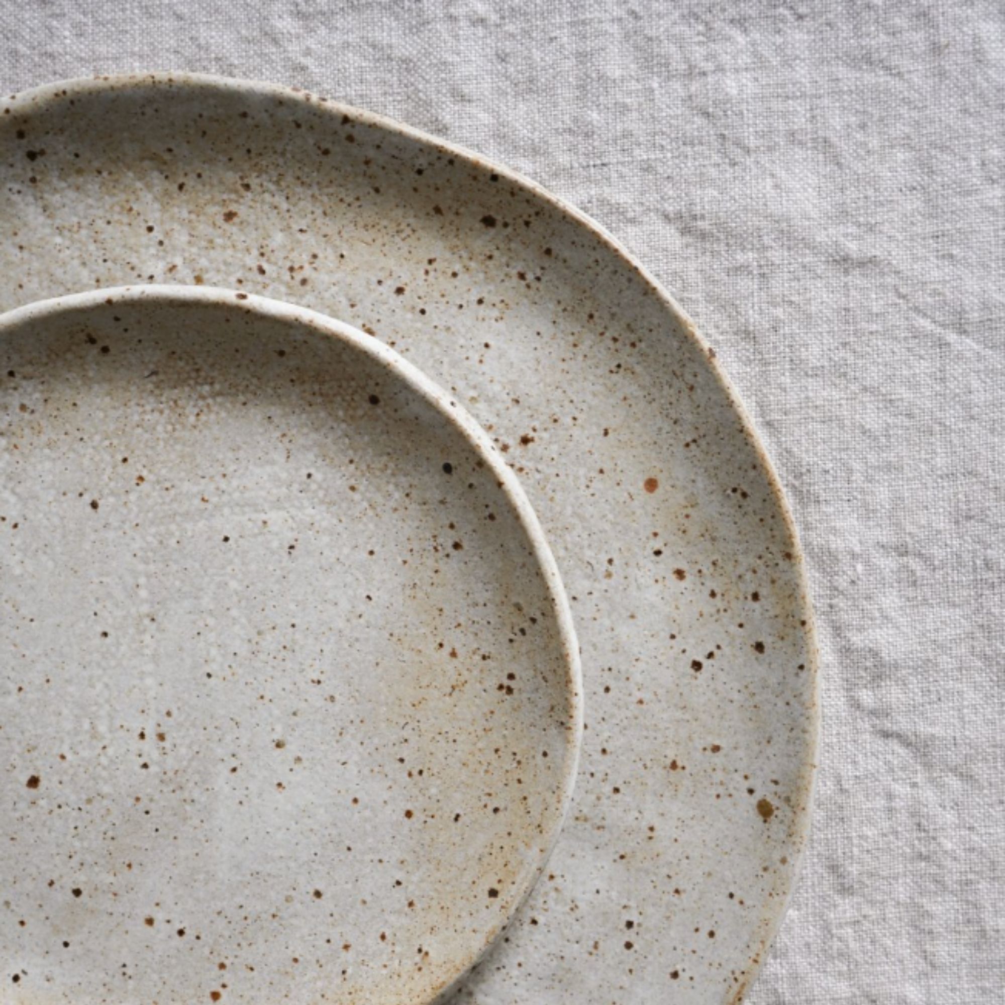 Speckled plates on a linen tablecloth