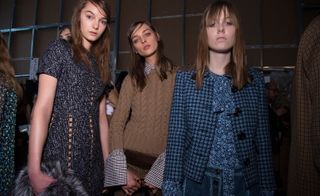 One model in a black and white dress, one in a brown wool sweater and one in a blue floral dress with a blue houndstooth coat