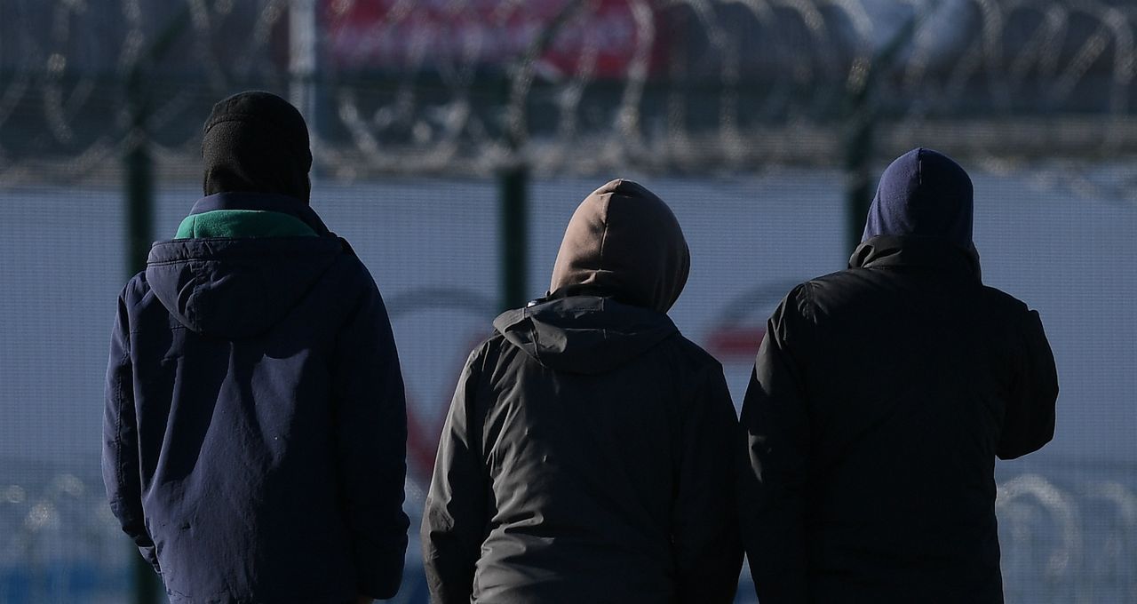 Men gather near a truck depot in Calais, France