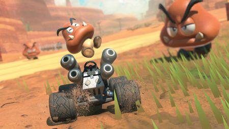 Mario Kart World screenshot showing a Goomba happily jumping out of a kart.