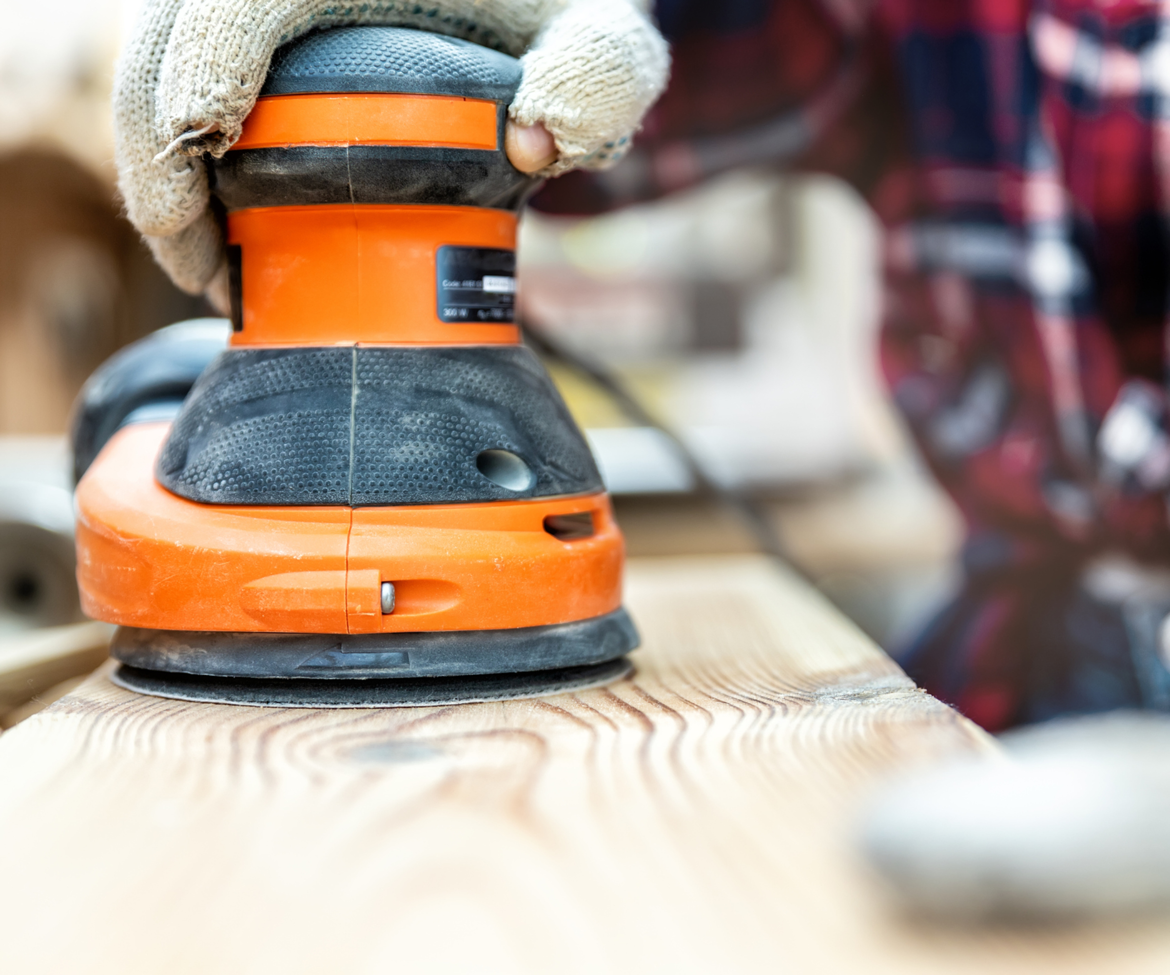 wood being sanded using orbital sander