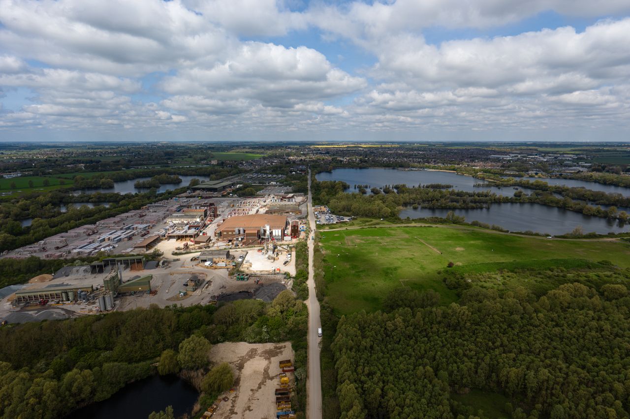 Image taken by the DJI Inspire 3 drone. He we see a 50/50 aerial shot of a quarry and a forest, side by side.
