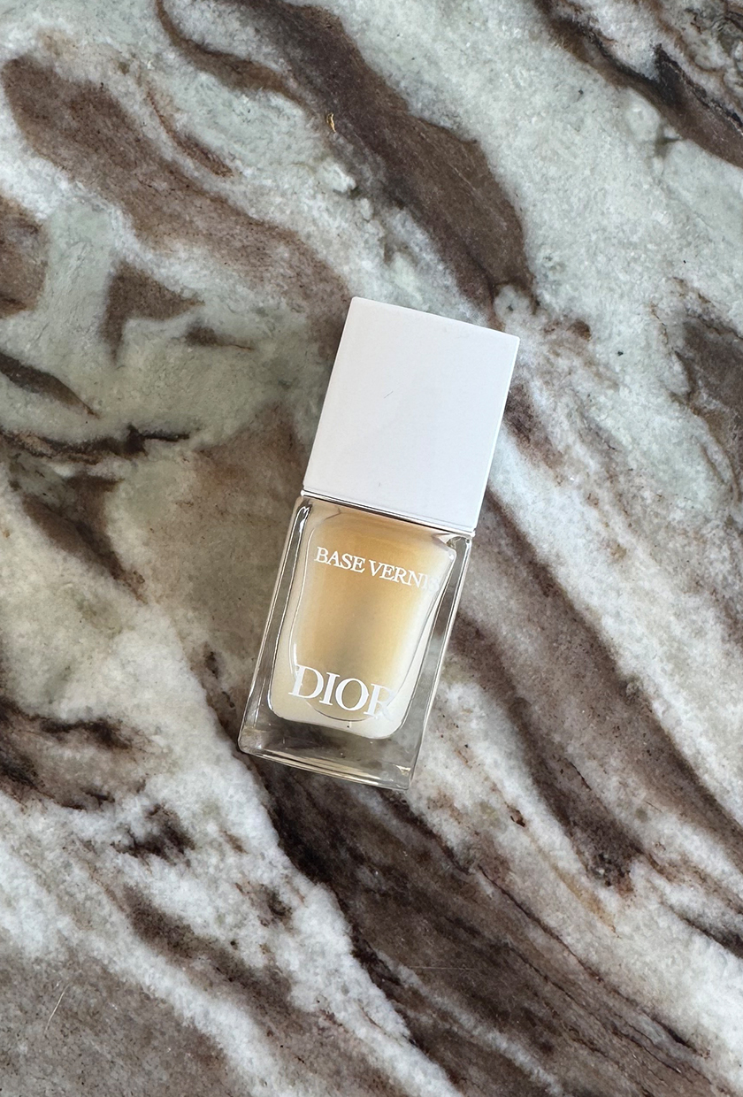 A photo of the Dior Base Vernis nail strengthening nail polish on a marble surface