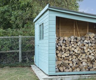Blue shed with log store
