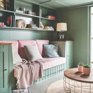 A colour-drenched green living room with built-in storage and sofa