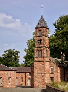 Fig 2: The restored stables and clock tower, on the site of a Roman barracks — Netherby Hall. ©Paul Highnam for Country Life