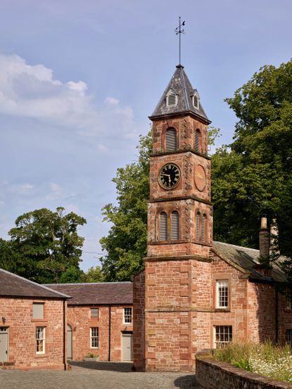 Fig 2: The restored stables and clock tower, on the site of a Roman barracks &mdash; Netherby Hall. &copy;Paul Highnam for Country Life
