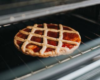 Delicious pie with criss-cross top on oven grate, ready for eating