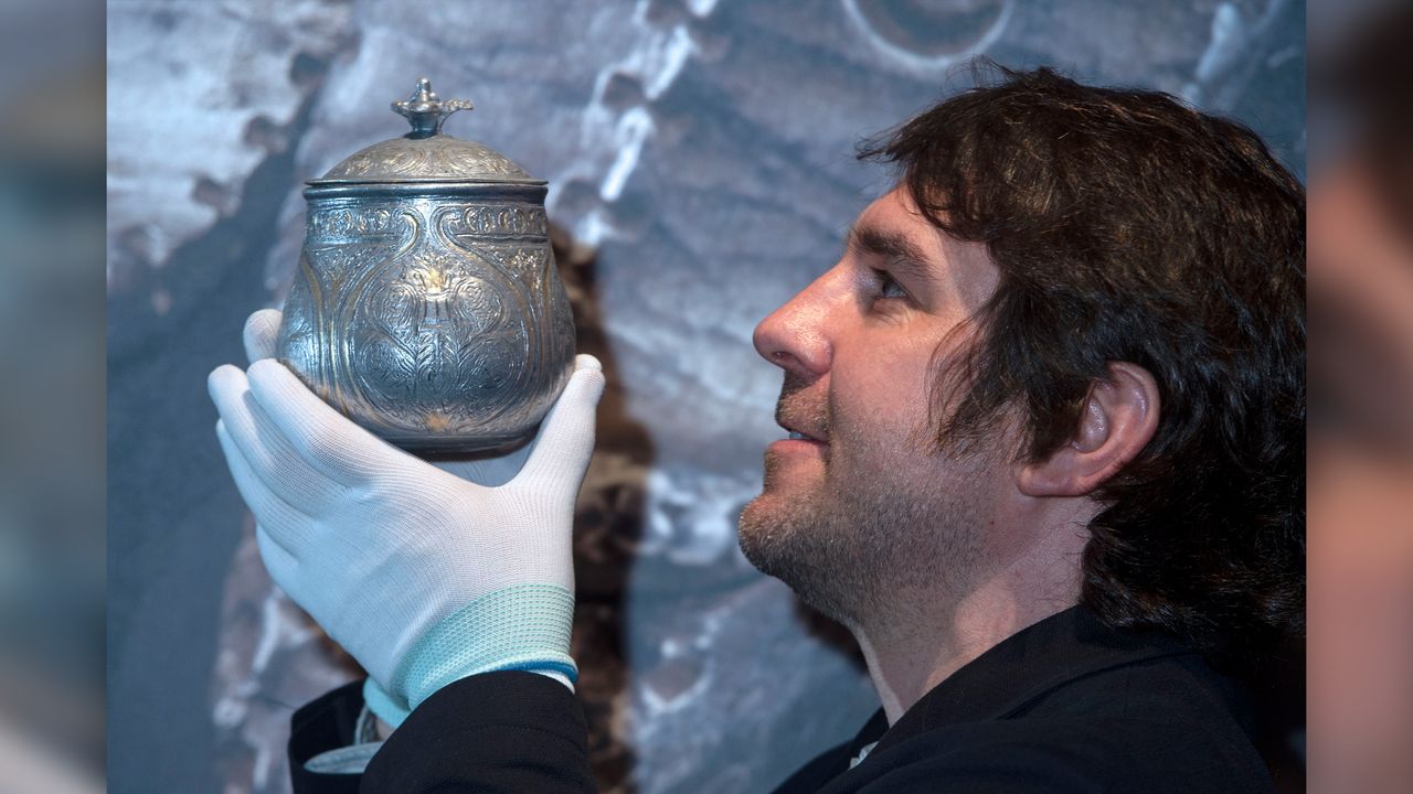 Curator Martin Goldberg holds a reconstruction of the vessel.