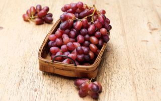 Basket of low calorie fruits, red grapes on the vine