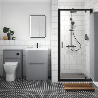 bathroom with white tiled wall and floor with black and white tiling