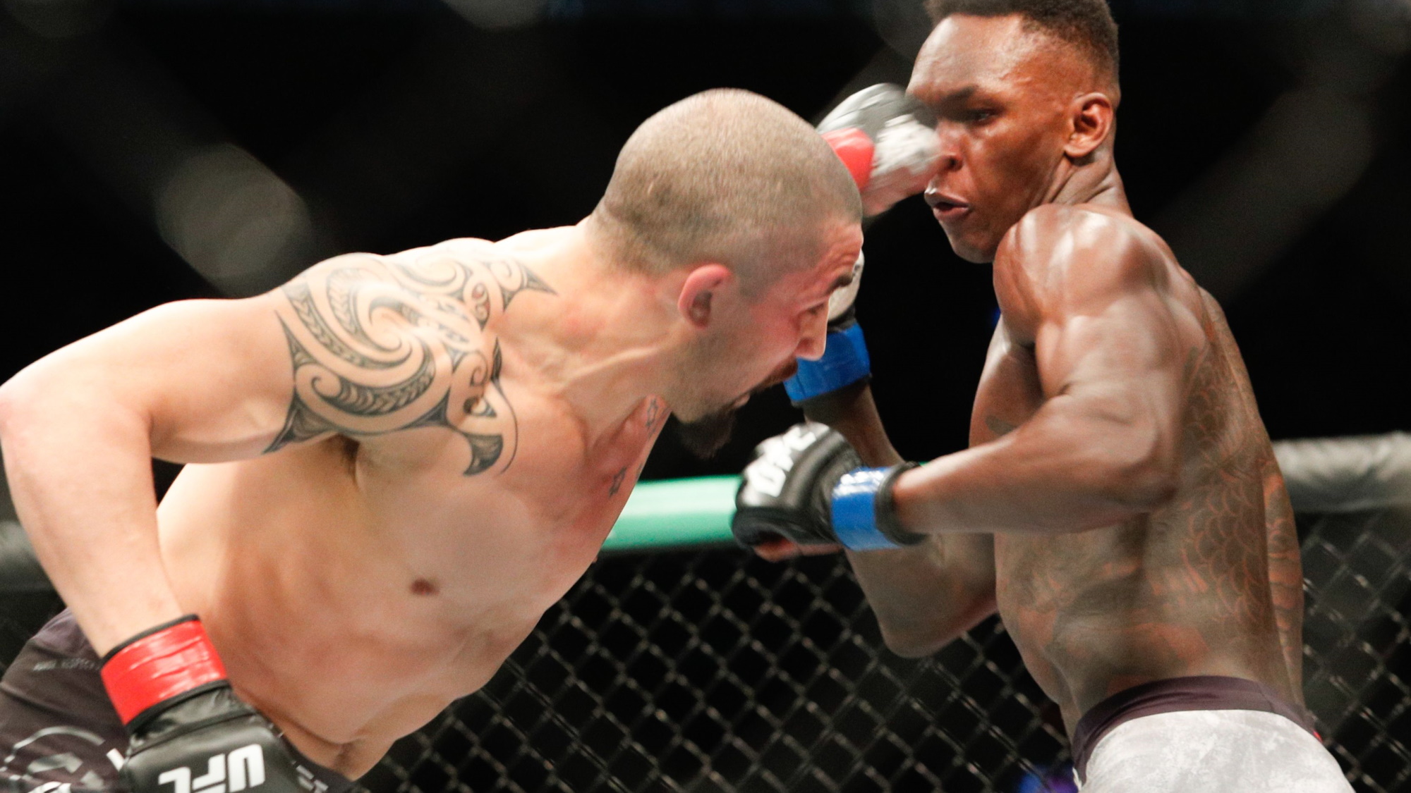 Robert Whittaker punching Israel Adesanya at UFC 243