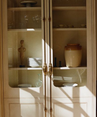 cabinet with glass fronts showing plates and glasses inside