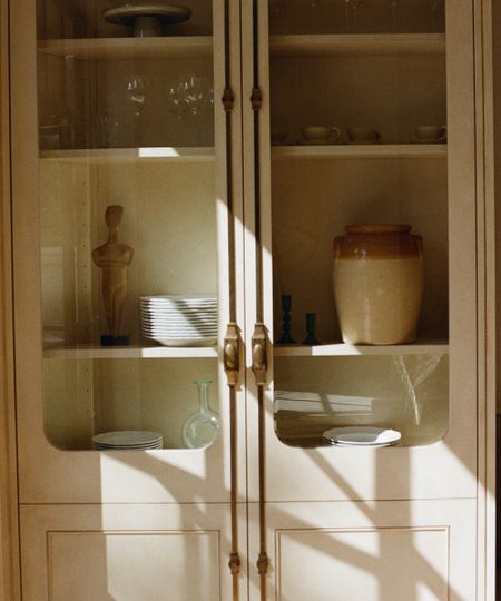 cabinet with glass fronts showing plates and glasses inside