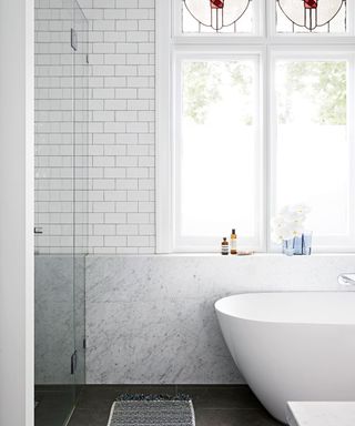 bathroom with white metro tiles, Carrara marble and freestanding bath designed by Sarah McPhee in Melbourne period house