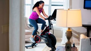 Woman riding exercise bike in her home