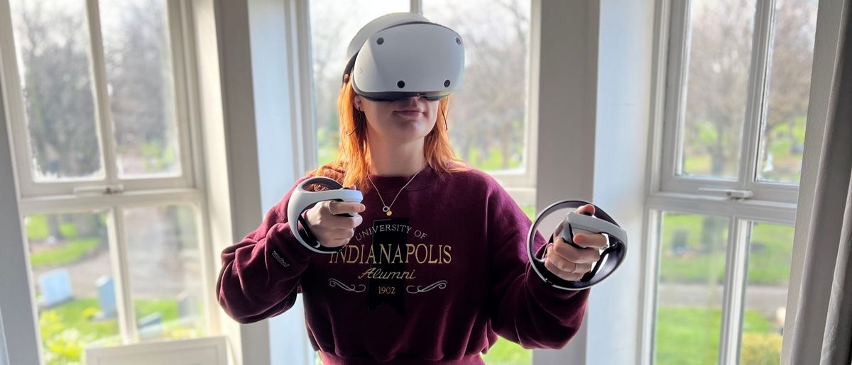 A person using the PlayStation VR 2 in front of a window.