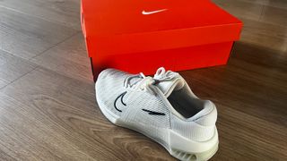 Nike Metcon 9 in white and black next to a shoe box